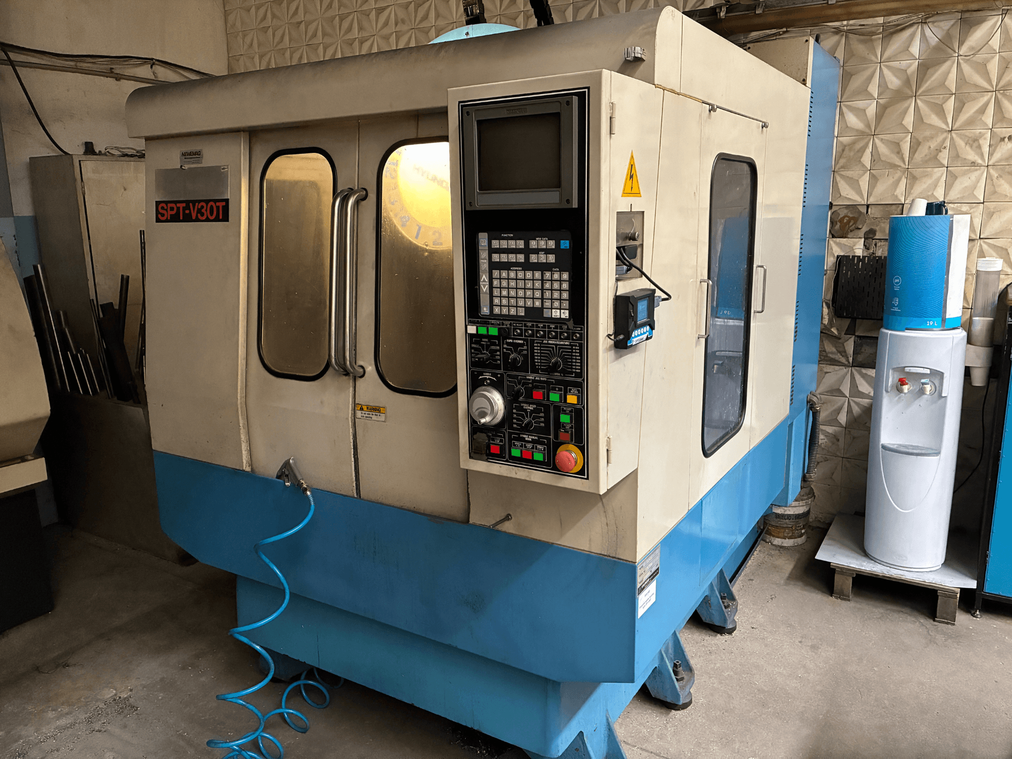 Промышленный фрезерный станок SPT-V30T, вид спереди, панель управления, кнопки и синий шланг.